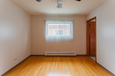 an empty room with wooden floors and a window