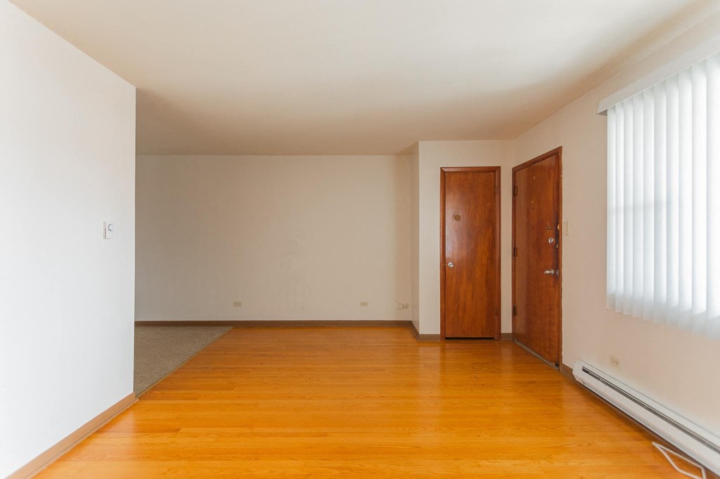 a empty living room with wood floors and white walls