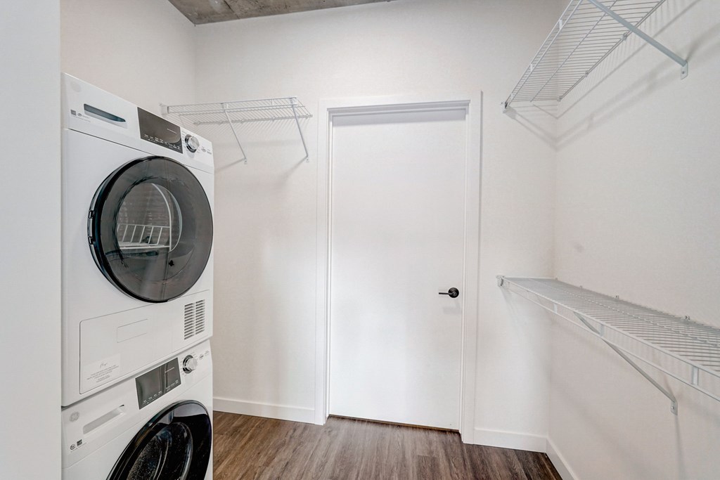 A white dryer is on the left of a white door.