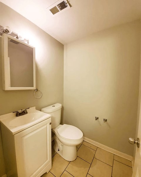 A white toilet and sink in a small bathroom.
