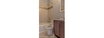 A white toilet sits next to a bathtub in a bathroom.