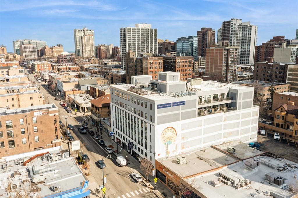 A city street with a large white building with a mural on the side.