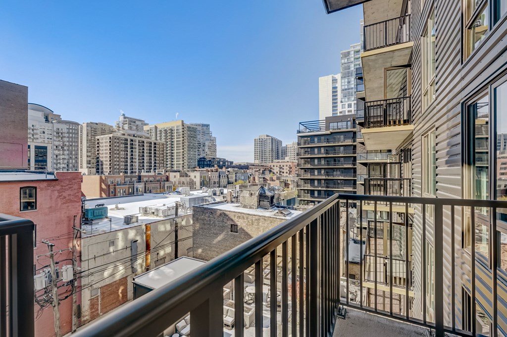 A balcony overlooks a cityscape with buildings of various heights.