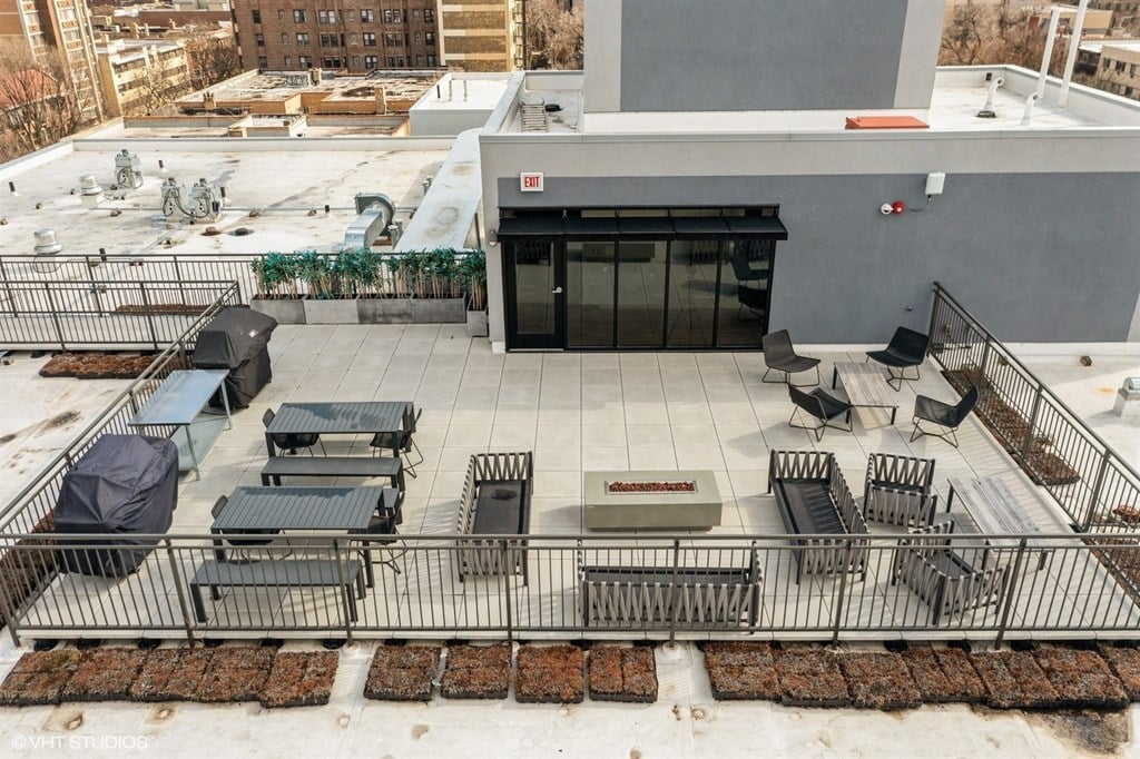 A rooftop patio with a table and chairs.