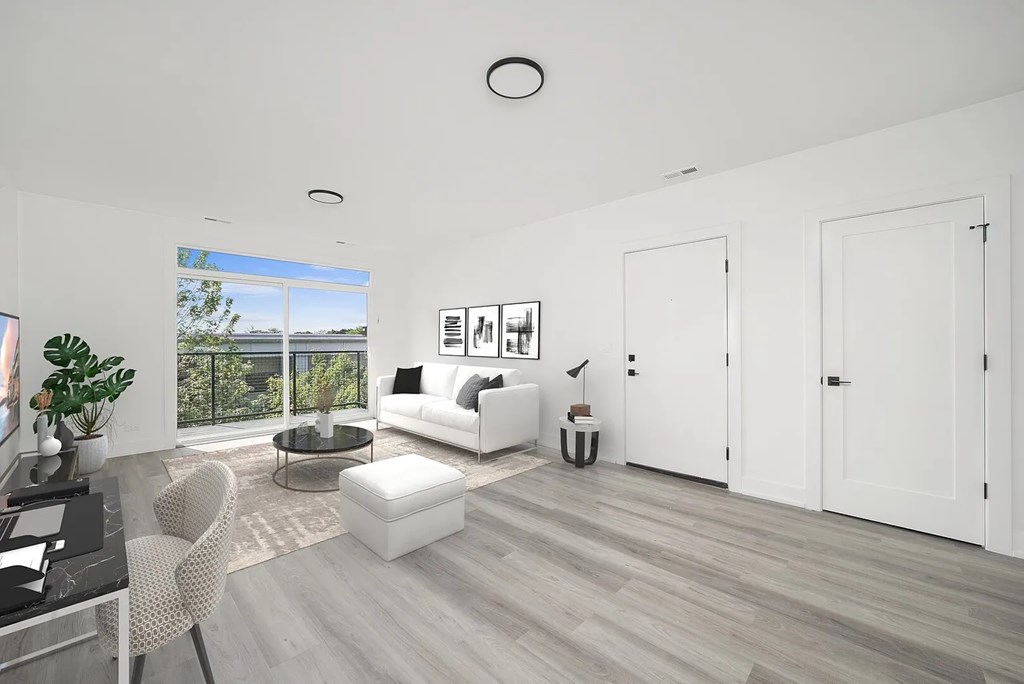 A modern living room with a glass table and white furniture.