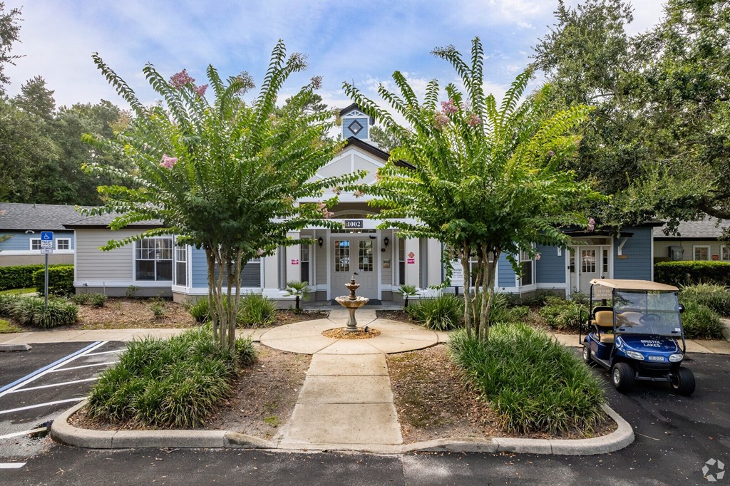 A golf cart is parked in front of a building with a clock tower.