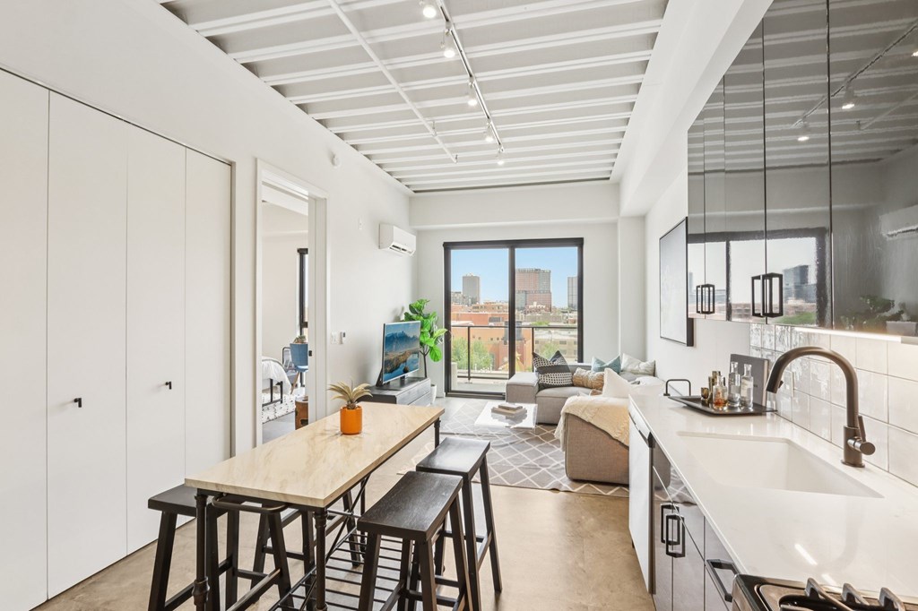 A kitchen with a table and chairs in front of a window.