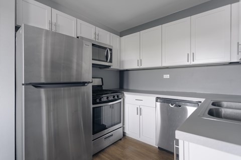 A modern kitchen with stainless steel appliances and white cabinets.