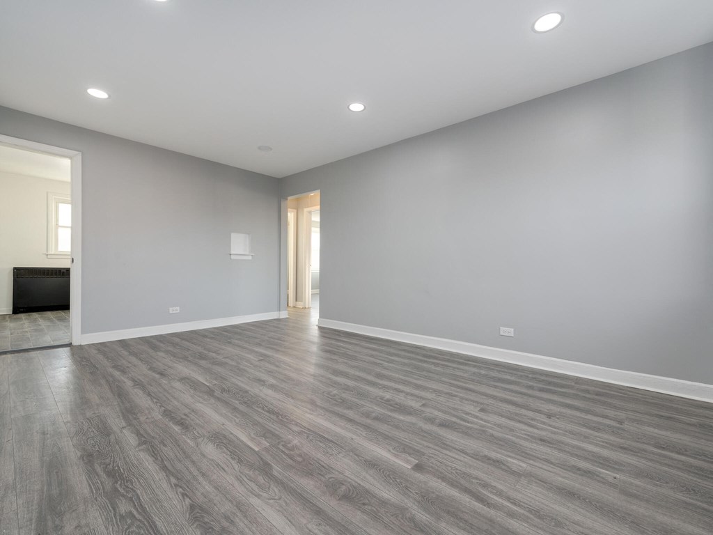 A spacious room with grey flooring and white walls.
