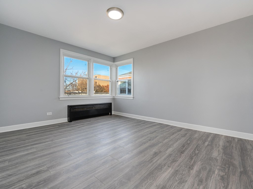 A room with a large window and a bench.