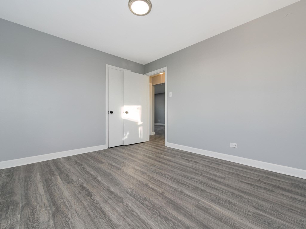 A room with a wooden floor and a white door.