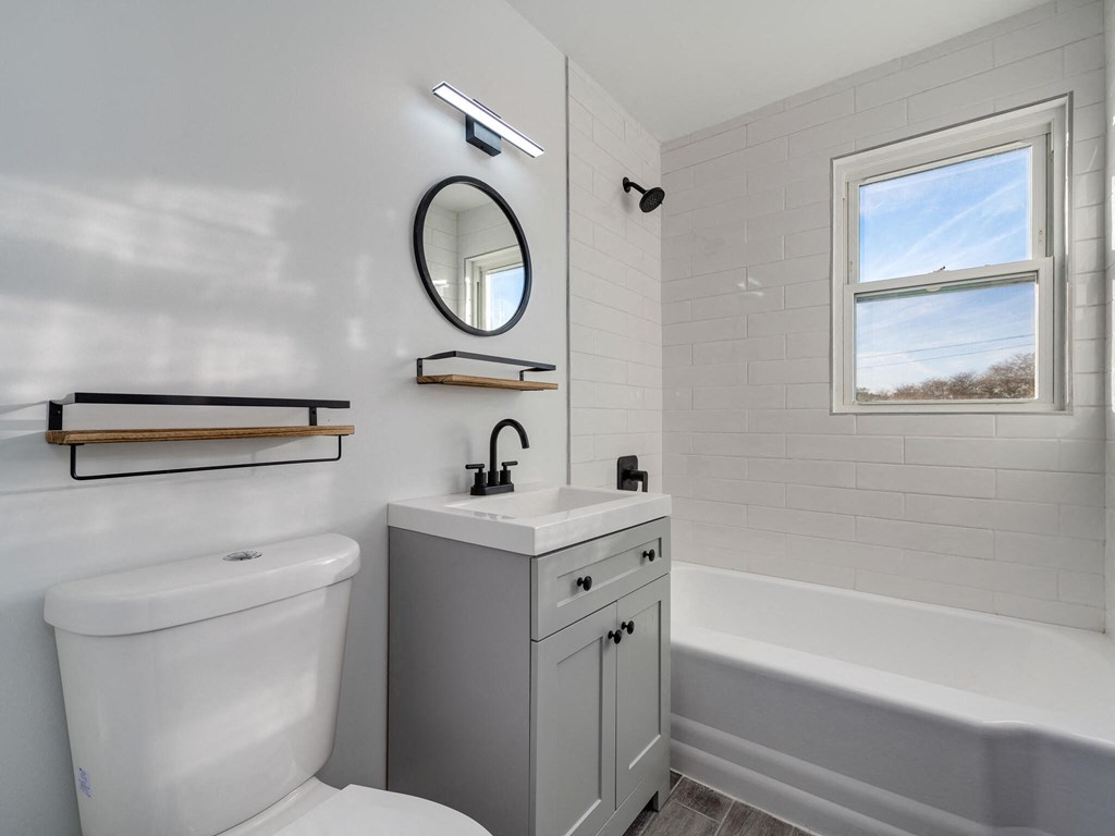 A white bathroom with a tub, toilet, and sink.