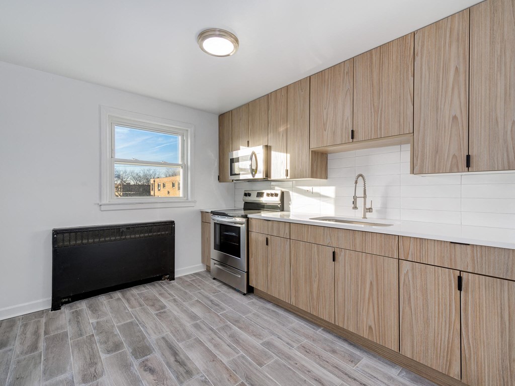 A kitchen with wooden cabinets and a black radiator.