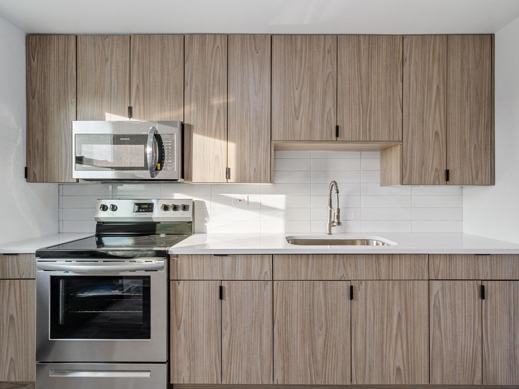 A modern kitchen with wooden cabinets and stainless steel appliances.
