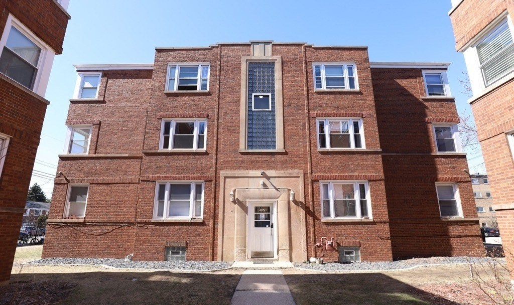 A red brick building with a central entrance and windows on all sides.