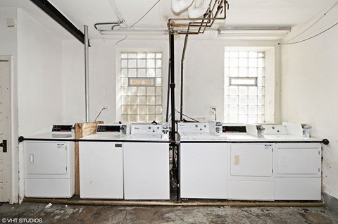 A white kitchen with a sink and a window.