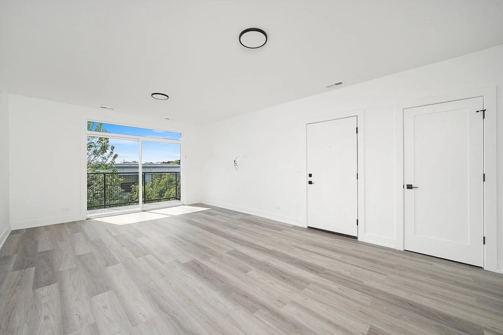 A room with a sliding glass door leading to a balcony.