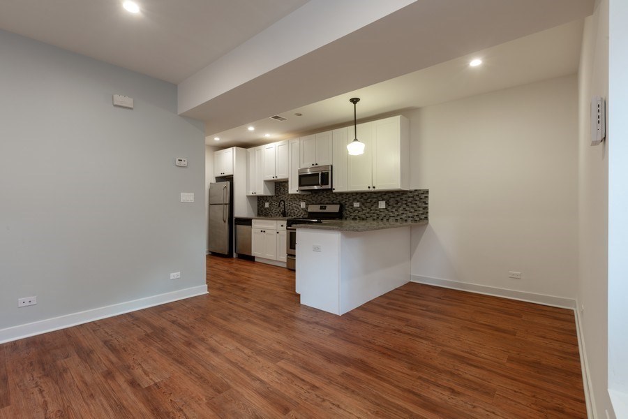A kitchen area with a white countertop and a white fridge.