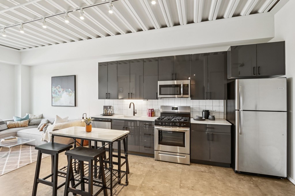 A modern kitchen with a refrigerator, stove, and oven.