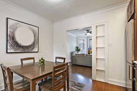 A dining room with a wooden table and chairs.