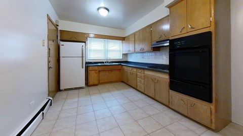 A kitchen with a black microwave above the stove and a white refrigerator.