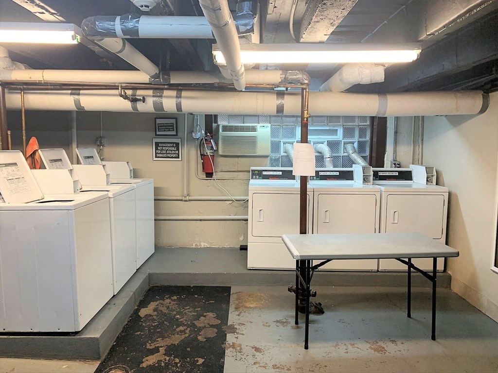 an empty room with washing machines and a table