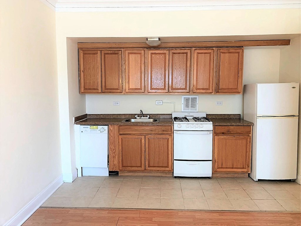 a kitchen with white appliances and wooden cabinets