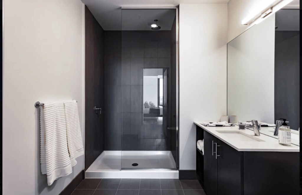 a black and white bathroom with a shower and sink