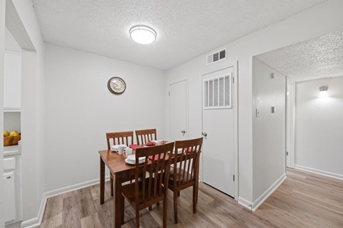 A dining room with a wooden table and chairs.