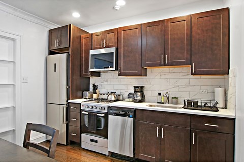 A kitchen with brown cabinets and stainless steel appliances.