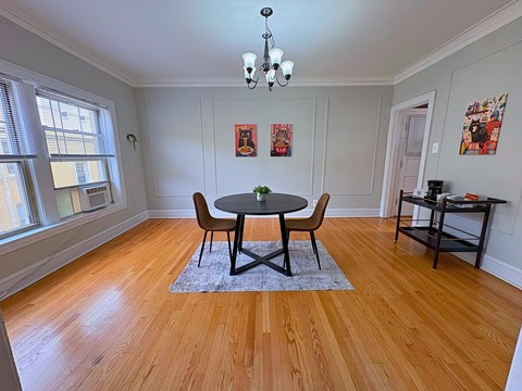 A dining room with a table and chairs.
