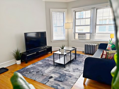 A living room with a blue couch and a black television.