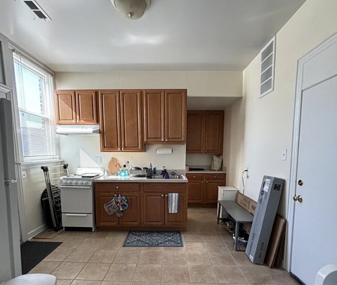 A kitchen with brown cabinets and a white refrigerator.
