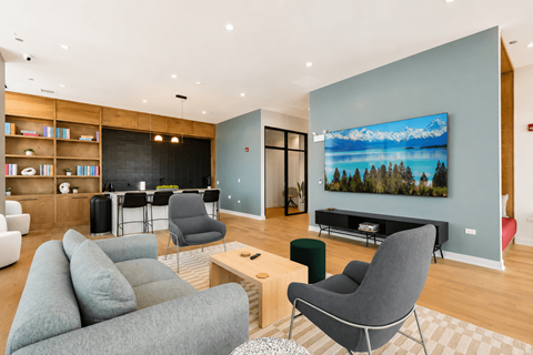 A living room with a grey couch, a chair, and a television.