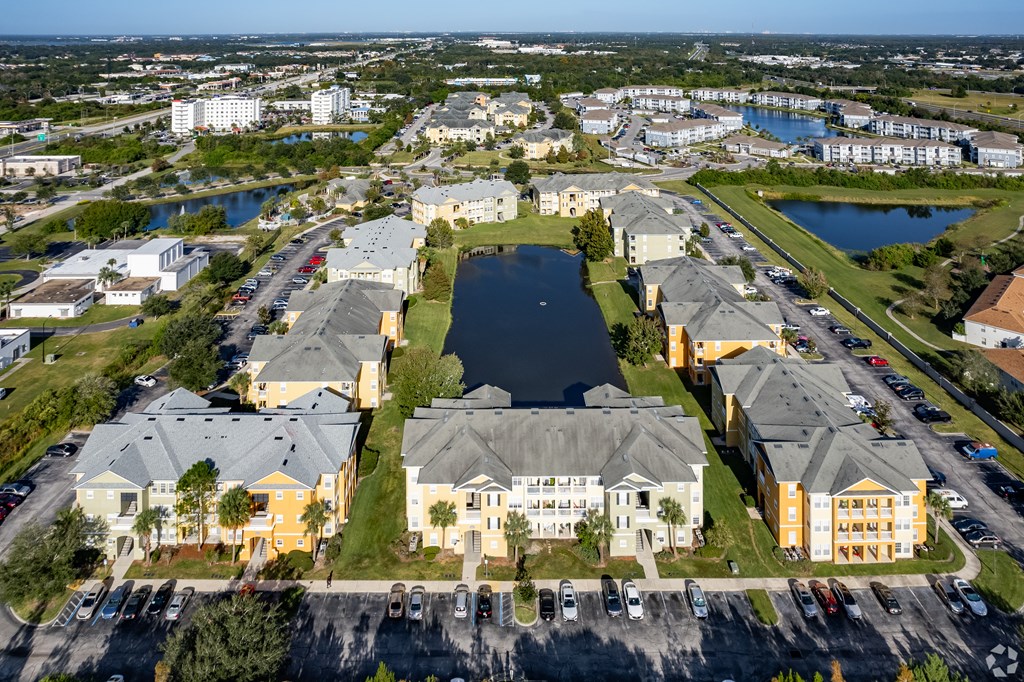 A large apartment complex with a lake in the middle.