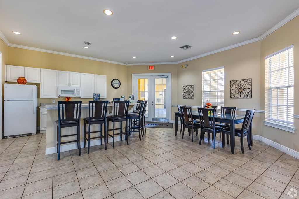 A kitchen with a dining table and chairs.