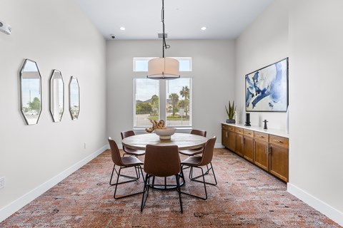 A dining room with a table and chairs.