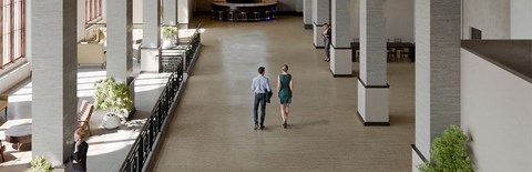 a man and a woman are walking through an empty building
