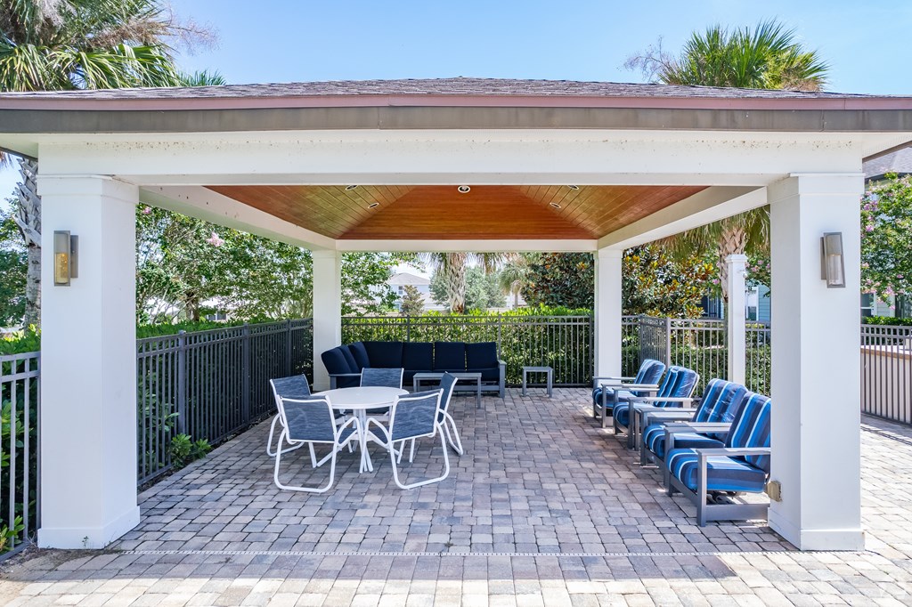 A patio with a table and chairs under a roof.
