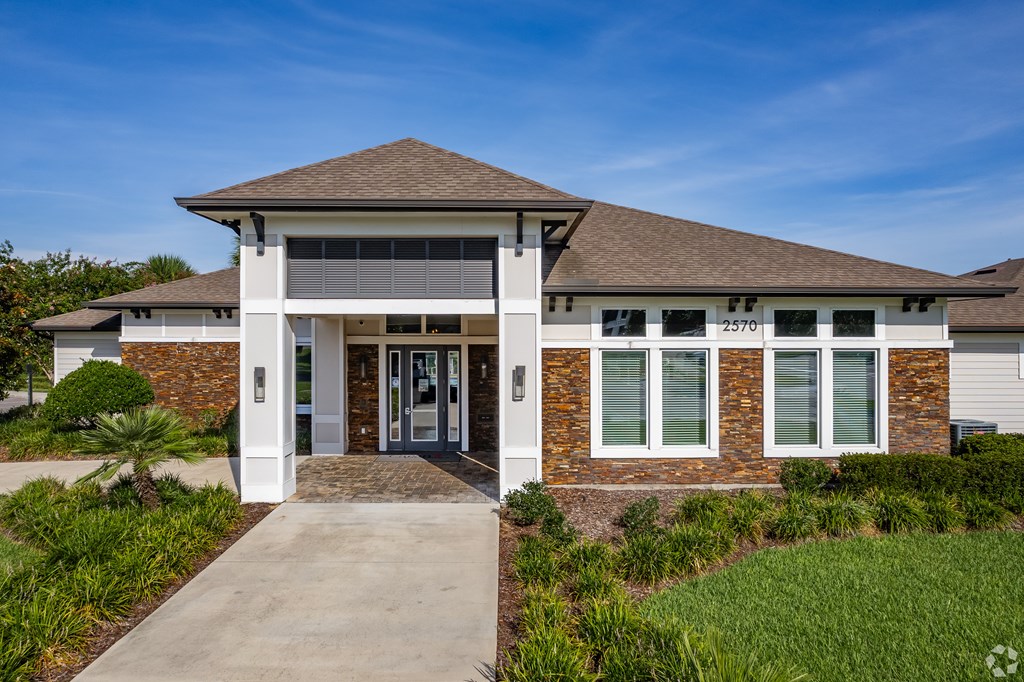 A modern building with a brick facade and a large glass window.