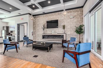 A living room with a fireplace and blue chairs.