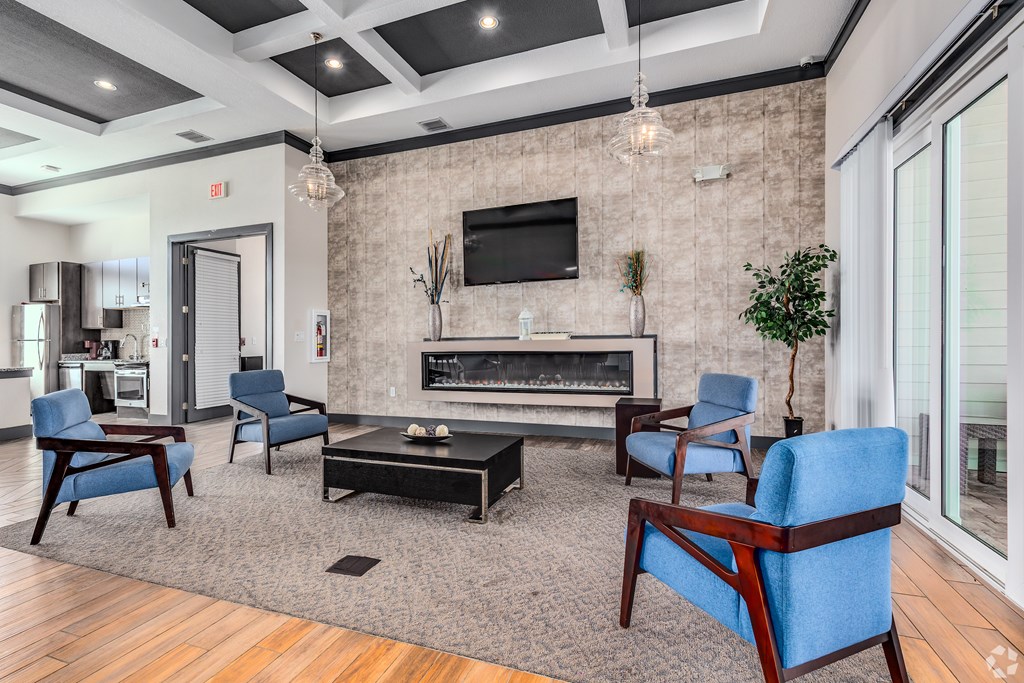 A living room with a fireplace and blue chairs.