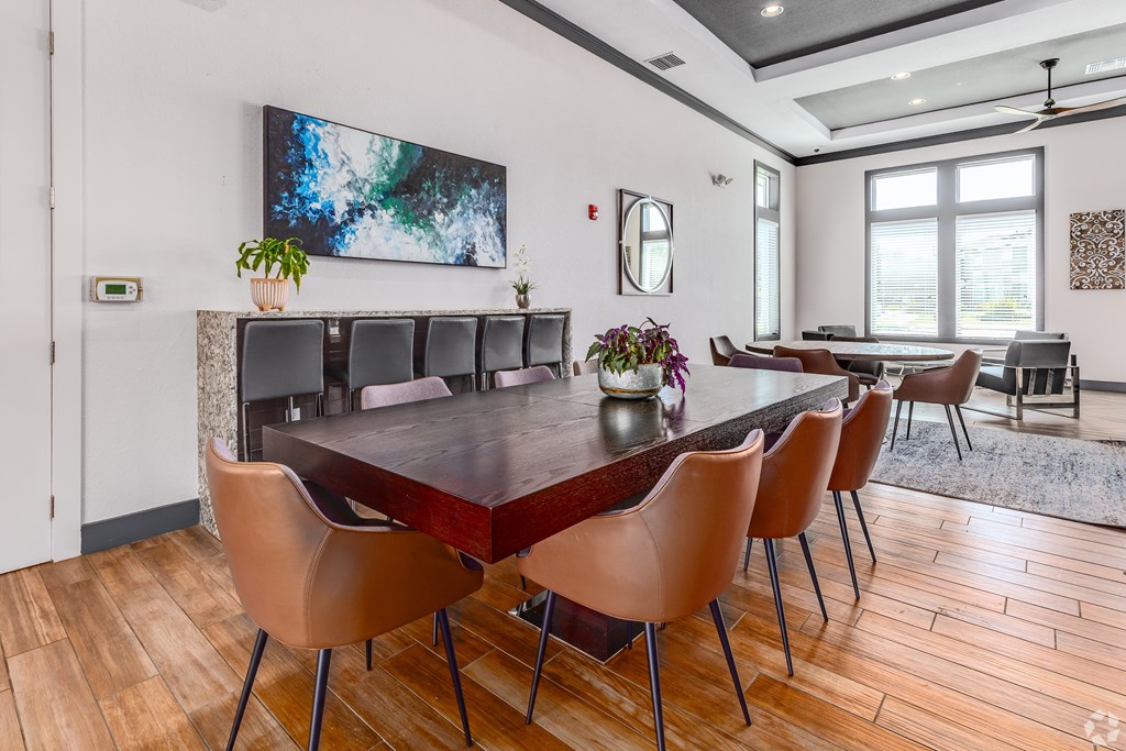 A modern dining room with a large table and chairs.