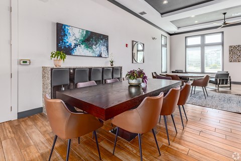 A modern dining room with a large table and chairs.