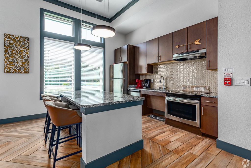 A kitchen with a bar area and a wood floor.
