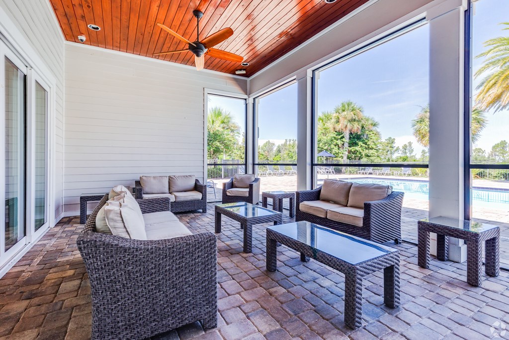 A patio with a ceiling fan and furniture.
