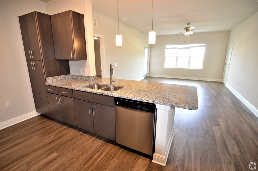 A kitchen with a granite countertop and stainless steel appliances.