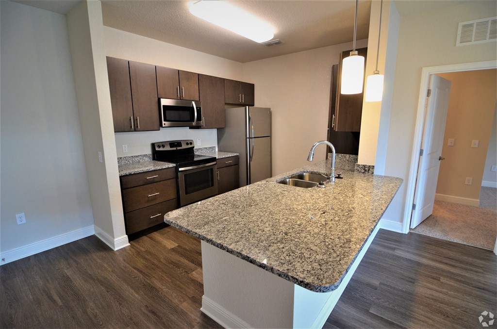 A kitchen with granite countertops and stainless steel appliances.