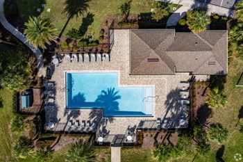 An aerial view of a house with a pool and palm trees.