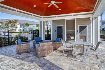 A patio with a table and chairs under a roof.